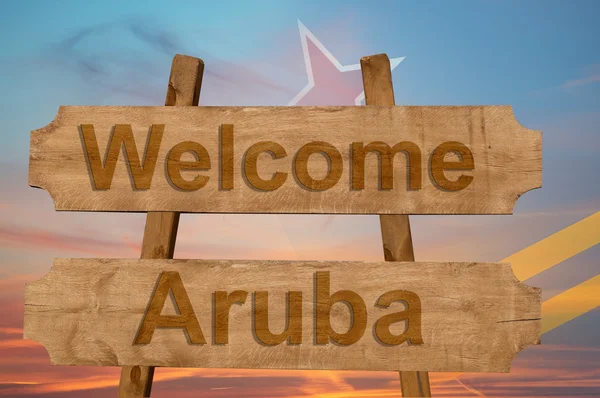 Bienvenido a Aruba cantar sobre fondo de madera con la mezcla de la bandera nacional — Foto de Stock