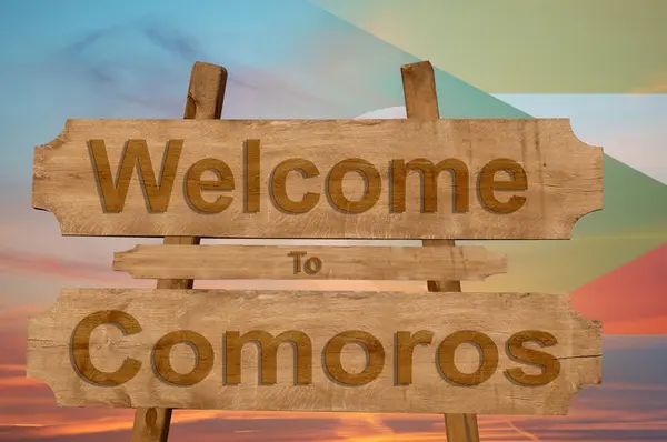 Bem-vindo ao Comores cantar em fundo de madeira com misturar bandeira nacional — Fotografia de Stock