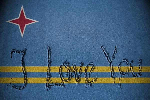 Eu te amo escrito na areia com a mistura de bandeira Aruba — Fotografia de Stock