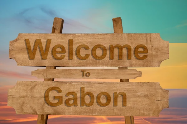 Welkom bij Gabon zingen op hout achtergrond met het mengen van de nationale vlag — Stockfoto