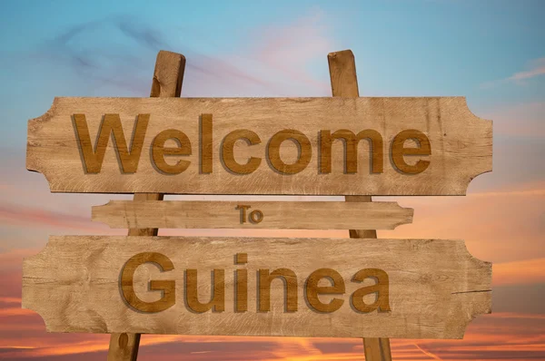 Benvenuti in Guinea cantare su sfondo di legno — Foto Stock