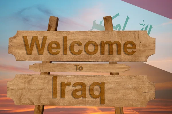 Bem-vindo ao Iraque cantar em fundo de madeira com misturando bandeira nacional — Fotografia de Stock