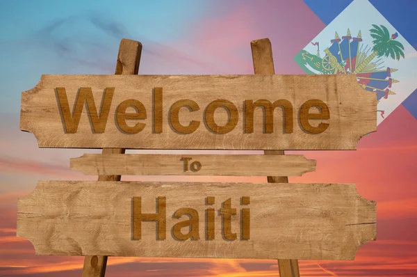 Bienvenido a Haití cantar sobre fondo de madera con la mezcla de la bandera nacional — Foto de Stock