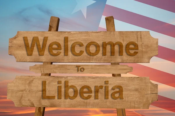 Ласкаво просимо в Ліберії знак на деревини фон з накладання Національний прапор — стокове фото
