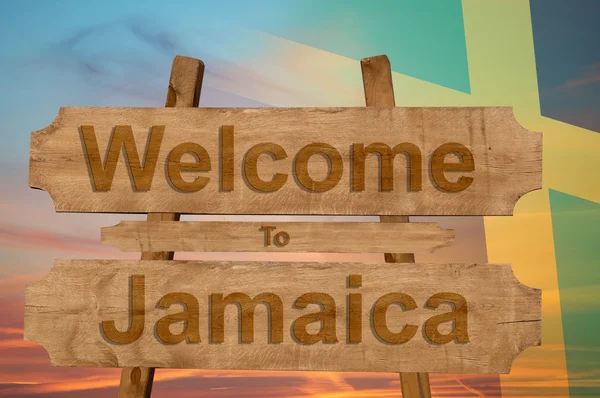 Bienvenido a Jamaica signo en el fondo de madera con la mezcla de la bandera nacional — Foto de Stock