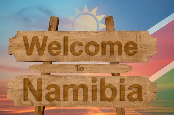 Добро пожаловать в Намибию знак на деревянном фоне с смешиванием национального флага — стоковое фото