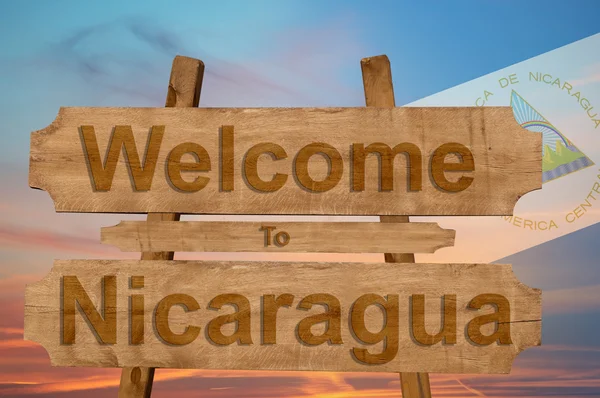 Ласкаво просимо в Нікарагуа знак на деревини фон з накладання Національний прапор — стокове фото