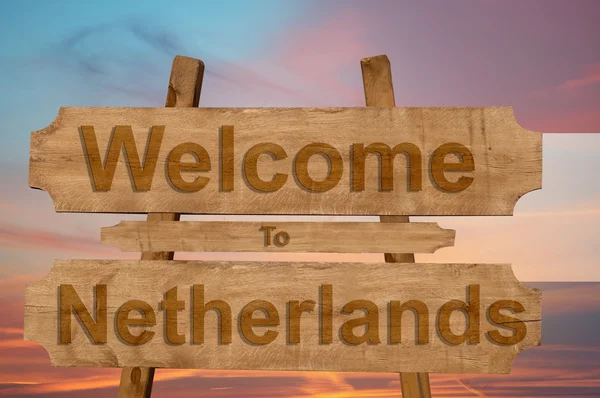 Ласкаво просимо в Нідерландах знак на деревини фон з накладання Національний прапор — стокове фото