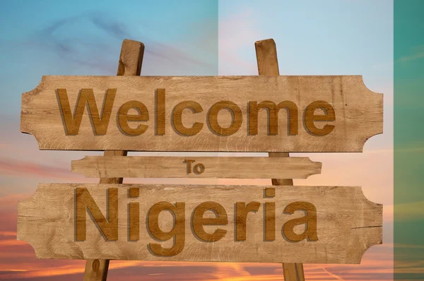 Benvenuti in Nigeria segno su sfondo di legno con la miscelazione bandiera nazionale — Foto Stock