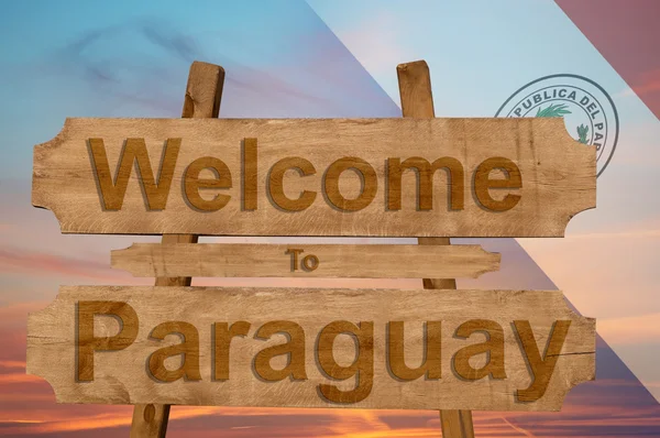 Bienvenido a Paraguay signo sobre fondo de madera con bandera nacional de mezcla — Foto de Stock