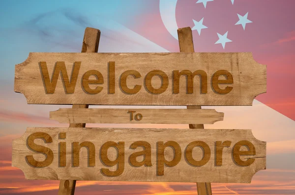 Bienvenido a Singapur signo en el fondo de madera con la mezcla de la bandera nacional — Foto de Stock