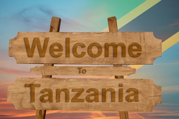 Benvenuti in Tanzania cantare su sfondo di legno con miscelazione bandiera nazionale — Foto Stock