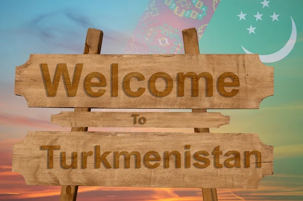 Welkom bij Turkmenistan zingen op hout achtergrond met het mengen van de nationale vlag — Stockfoto