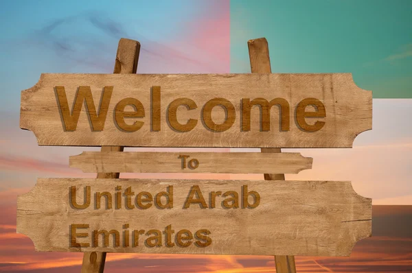 Ласкаво просимо в Об'єднаних Арабських Еміратах співати на деревини фон з накладання Національний прапор — стокове фото