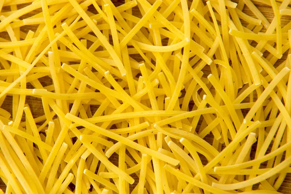 Kleine droge pasta noedels op hout achtergrond of textuur — Stockfoto