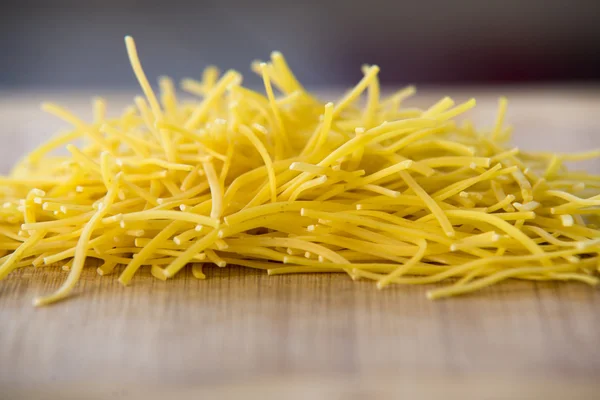 Pequeños fideos de pasta seca en madera — Foto de Stock