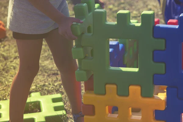 Jong meisje spelen met bakstenen in de tuin, vintage effect — Stockfoto