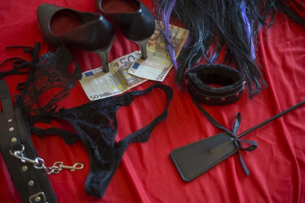 Концепция проститутки или стриптиза, банкнота в 50 евро с секс-игрушками на красной кровати — стоковое фото