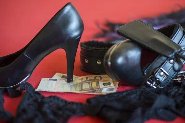 Prostituta o spogliarello concetto, 50 euro banknot con giocattoli del sesso sul letto rosso — Foto Stock