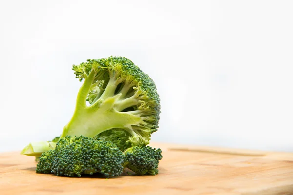 Close up on Fresh broccoli solated on wooden and white background — Stock Photo, Image