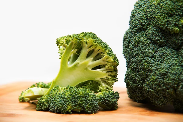 Close up on Fresh broccoli solated on wooden and white background — Stock Photo, Image