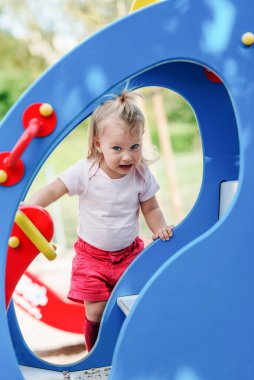 Genç sarışın kız çocuk parkında iyi eğlenceler.