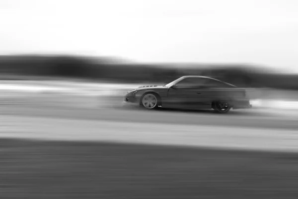 Condução muito rápida, movimento borrão deriva preto e branco — Fotografia de Stock