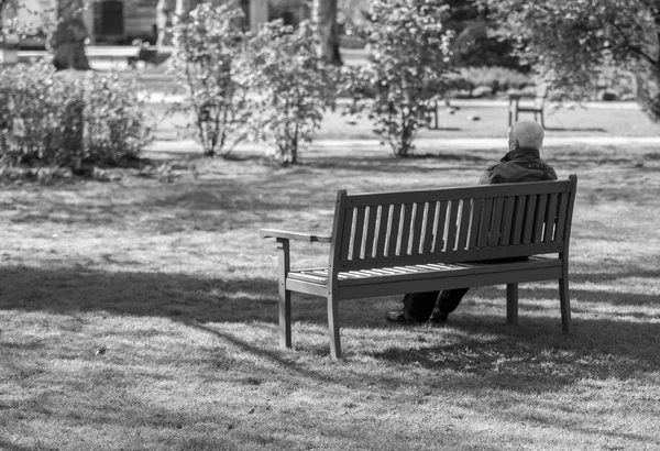 Vieil homme assis sur un banc — Photo