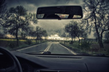 Yağmur damlaları ile araba penceresinden yol görünümü