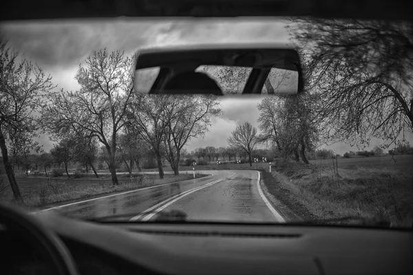 Kör längs motorvägen på en regnig dag, svart och vitt — Stockfoto