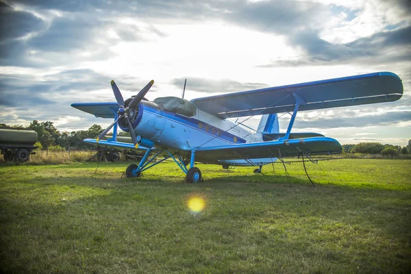 Παλιό αεροπλάνο για πράσινη χλόη και φόντο ηλιοβασίλεμα — Φωτογραφία Αρχείου