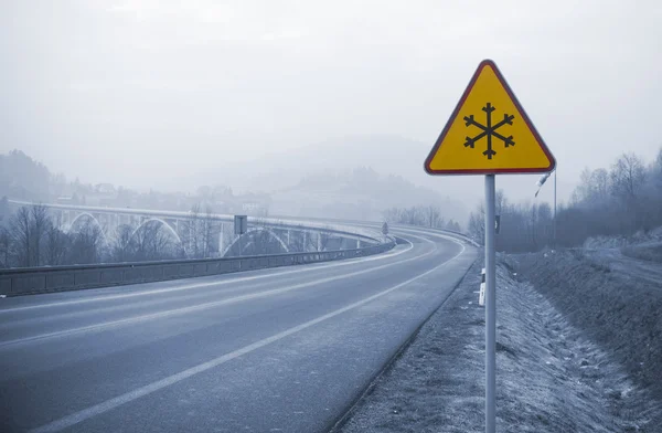 Carretera nevada con signo congelado en invierno, concepto frío — Foto de Stock