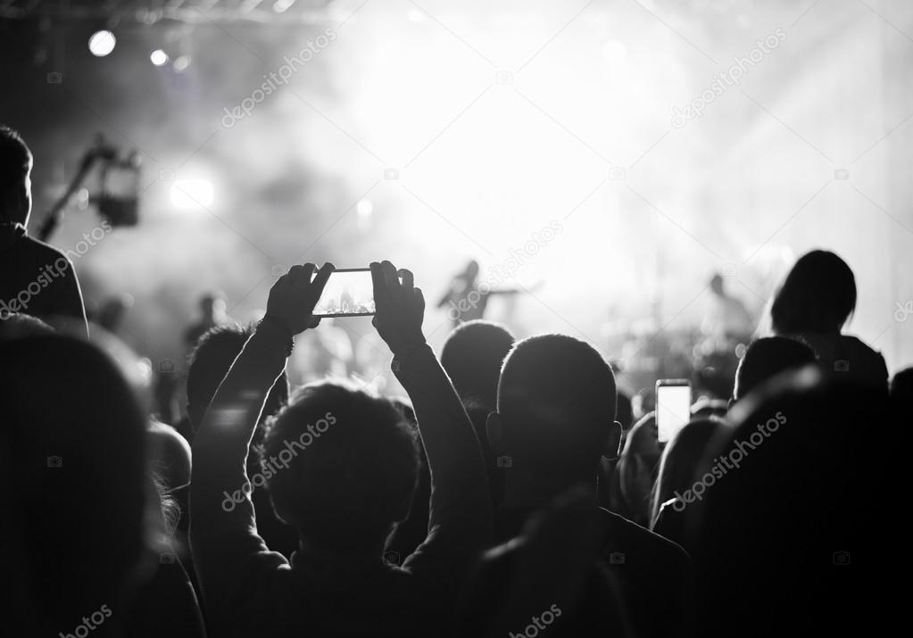 Supporters recording at concert, black and white, noise