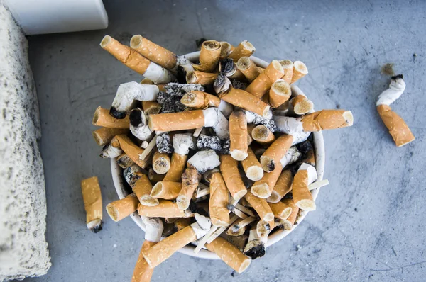 Schlechte Sucht. Aschenbecher und Zigaretten in Großaufnahme — Stockfoto