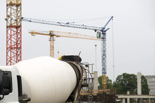 Gebouw in aanbouw op een bouwterrein met kraan en beton mixer — Stockfoto