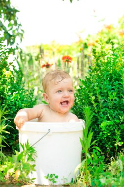 Çocuk bir havzasında açık havada oturur