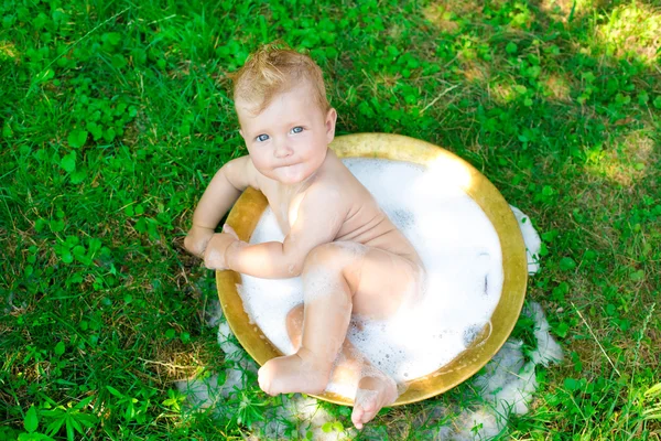 Enfant assis dans un bassin à l'extérieur — Photo