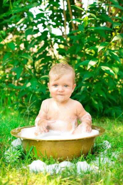 Barnet sitter ute i et basseng – stockfoto