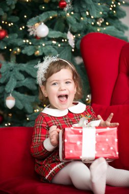 Mutlu, küçük, gülümseyen kız Noel hediyesi kutusuyla.