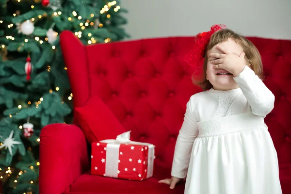Glad liten leende flicka med jul presentförpackning. — Stockfoto