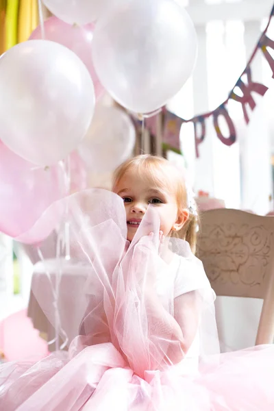 Krásná dívka sedí na židli na dovolené v svěží sukni a — Stock fotografie