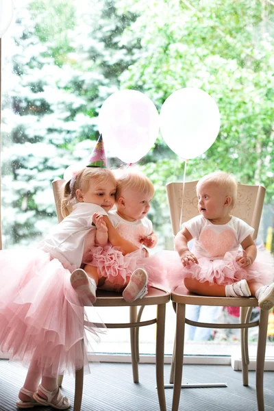 Zwei kleine Mädchen eineiige Zwillingsschwestern. geschmückter Geburtstagskuchen — Stockfoto
