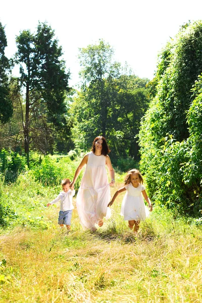 Mamá con niños corriendo en el parque —  Fotos de Stock