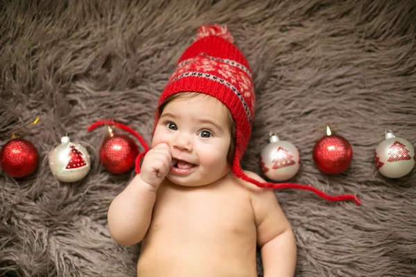 Dítě v červeném klobouku s vánoční koule — Stock fotografie