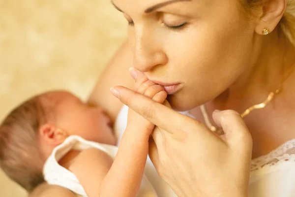 Moeder pasgeboren zoon hand kussen — Stockfoto