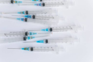 Boş tıbbi şırıngalar konteynırlarda, beyaz arka planda yatıyor.