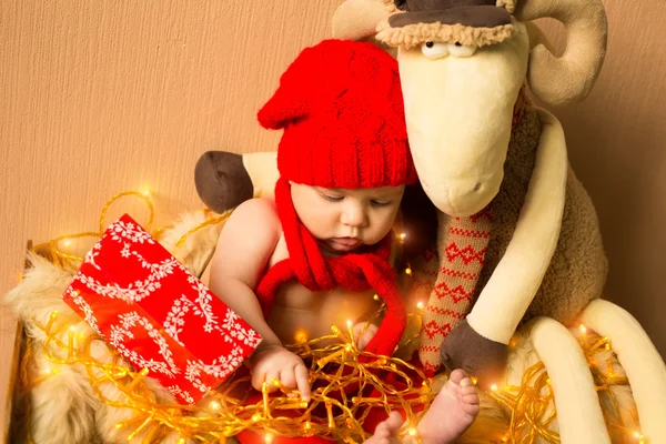 Kind mit Spielzeugschaf und Weihnachtsbeleuchtung — Stockfoto