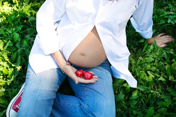 Schwangere hält Herzen in der Hand — Stockfoto