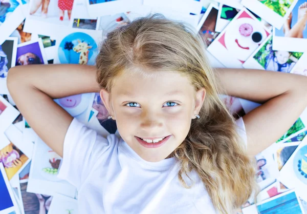 Girl lying on photos — Stock Photo, Image