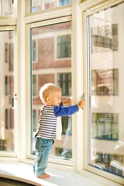 Piccolo ragazzo guardando la finestra — Foto Stock